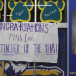 Maestra apasionada enseñando biología a un grupo diverso de estudiantes de secundaria en un laboratorio moderno.