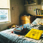 Habitación infantil vacía con una carpeta de documentos de emergencia sobre la cama, simbolizando a los niños separados de sus padres.